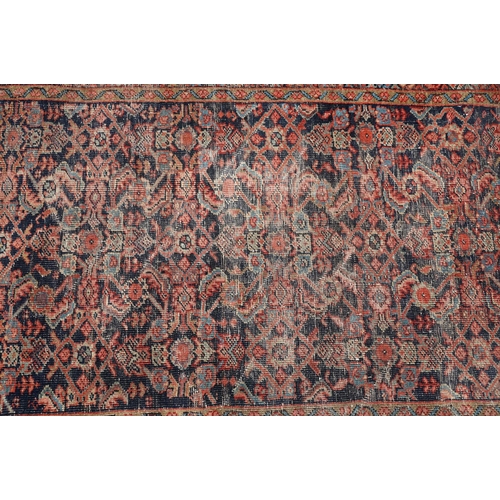 770 - Middle Eastern red ground carpet of geometric design, 310 x 142cm