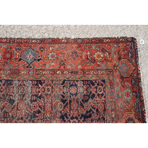 770 - Middle Eastern red ground carpet of geometric design, 310 x 142cm