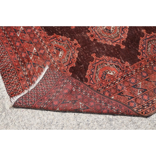 771 - Middle Eastern red ground carpet, with two central medallions within geometric borders, 216 x 140cm