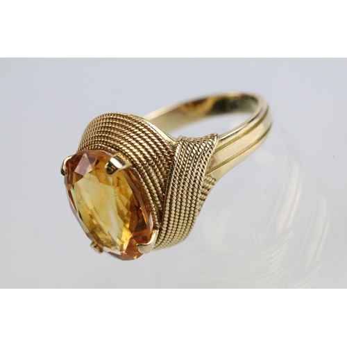 26 - 18ct gold and citrine dress ring being set with an oval cut citrine to the head within a rope twist ... 