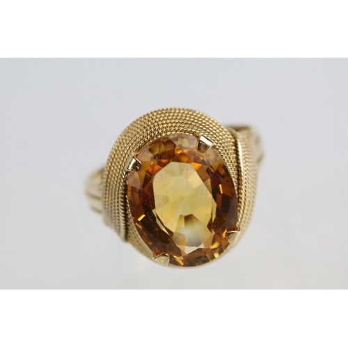 26 - 18ct gold and citrine dress ring being set with an oval cut citrine to the head within a rope twist ... 