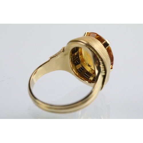 26 - 18ct gold and citrine dress ring being set with an oval cut citrine to the head within a rope twist ... 