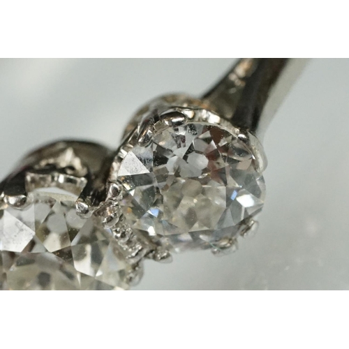 3 - Three stone diamond and platinum ring. The ring being set with three round old cut diamonds in prong... 