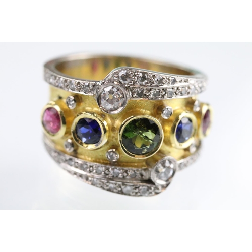 35 - 18ct gold, ruby, sapphire and diamond ring. The ring bezel set with a green round cut sapphire to ce... 