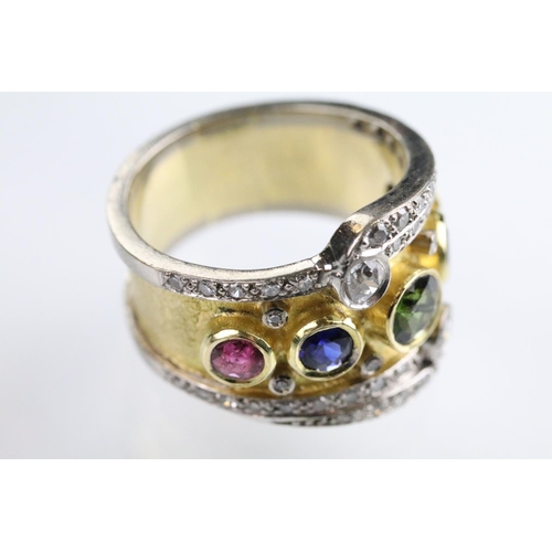 35 - 18ct gold, ruby, sapphire and diamond ring. The ring bezel set with a green round cut sapphire to ce... 