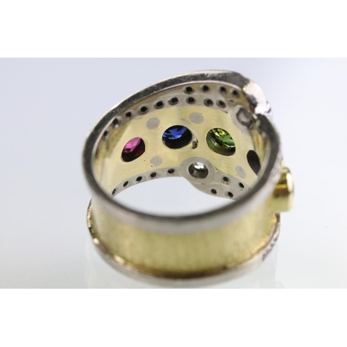 35 - 18ct gold, ruby, sapphire and diamond ring. The ring bezel set with a green round cut sapphire to ce... 