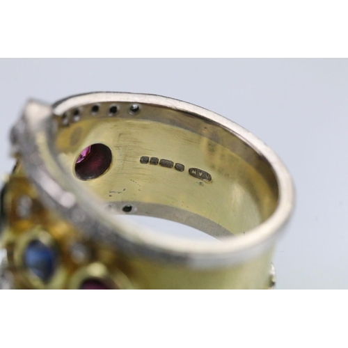 35 - 18ct gold, ruby, sapphire and diamond ring. The ring bezel set with a green round cut sapphire to ce... 