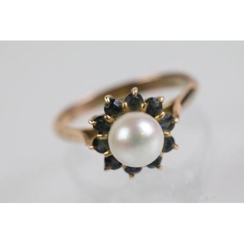 51 - Gold pearl and blue stone ring. The ring being set with a pearl to cultured centre with a halo of ro... 