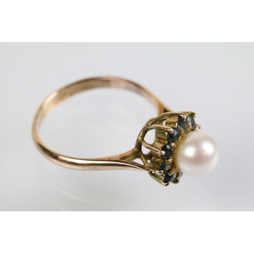 51 - Gold pearl and blue stone ring. The ring being set with a pearl to cultured centre with a halo of ro... 