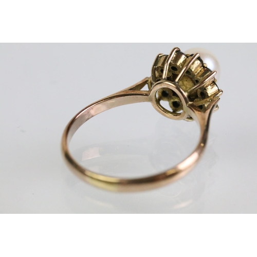 51 - Gold pearl and blue stone ring. The ring being set with a pearl to cultured centre with a halo of ro... 