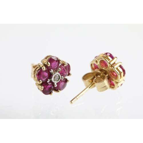 60 - Pair of 9ct gold ruby and diamond cluster earrings. The earrings set with a round cut diamond to the... 