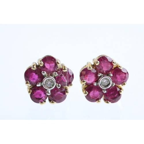 60 - Pair of 9ct gold ruby and diamond cluster earrings. The earrings set with a round cut diamond to the... 