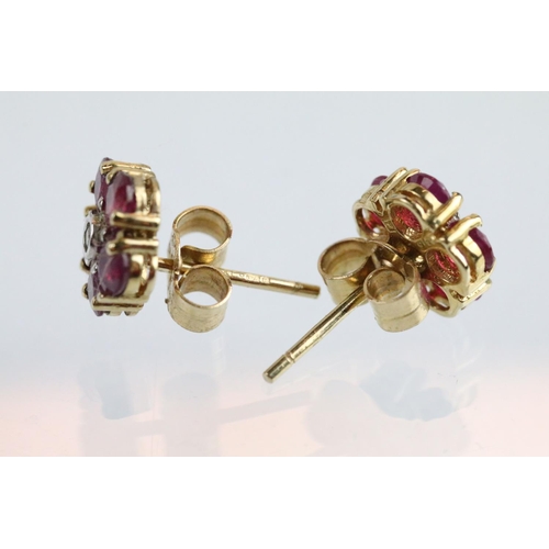 60 - Pair of 9ct gold ruby and diamond cluster earrings. The earrings set with a round cut diamond to the... 