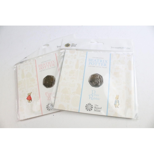 134 - A collection of fifteen Royal Mint Beatrix Potter 50p coin collectors packs together with five Winni... 