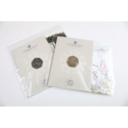 134 - A collection of fifteen Royal Mint Beatrix Potter 50p coin collectors packs together with five Winni... 