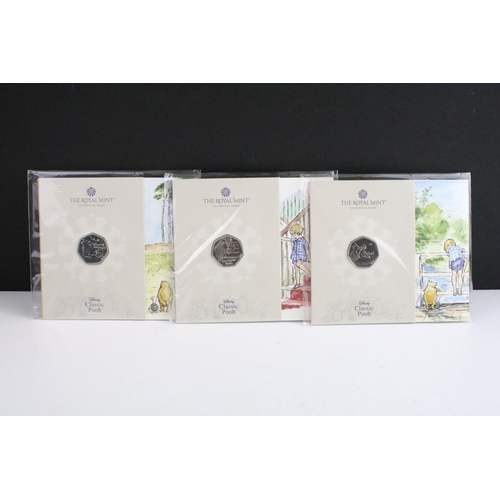 134 - A collection of fifteen Royal Mint Beatrix Potter 50p coin collectors packs together with five Winni... 