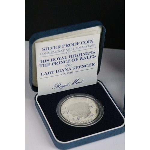 64 - A collection of four Royal Mint silver proof crown coins all encapsulated within display cases.