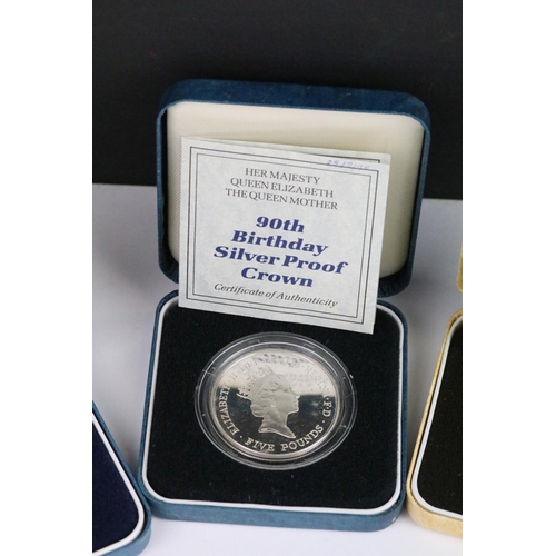 64 - A collection of four Royal Mint silver proof crown coins all encapsulated within display cases.