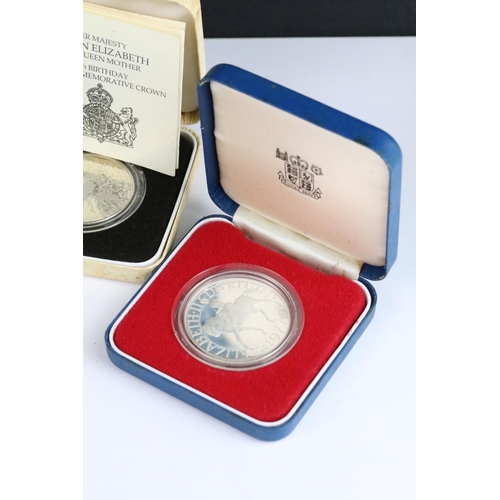 64 - A collection of four Royal Mint silver proof crown coins all encapsulated within display cases.