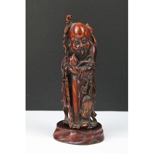 312 - An ornamental figure of an oriental gentleman in traditional dress together with an amber coloured o... 