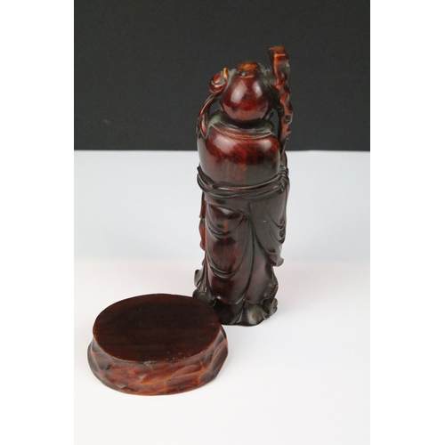 312 - An ornamental figure of an oriental gentleman in traditional dress together with an amber coloured o... 