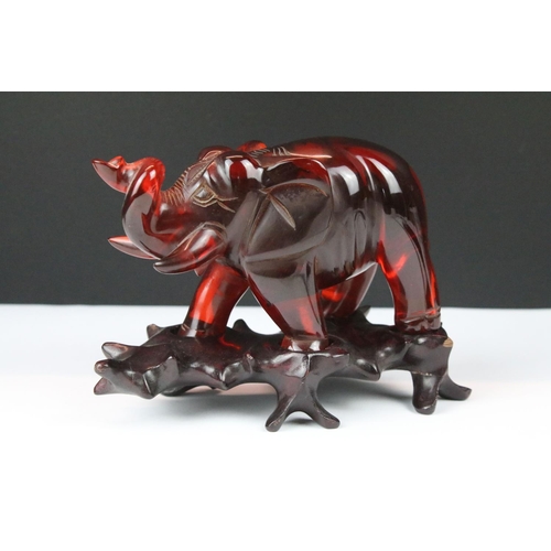 312 - An ornamental figure of an oriental gentleman in traditional dress together with an amber coloured o... 