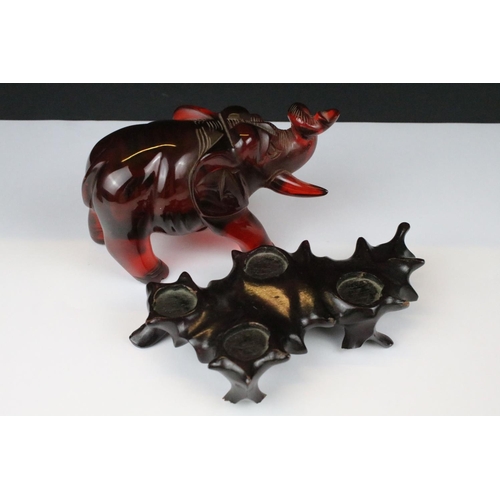 312 - An ornamental figure of an oriental gentleman in traditional dress together with an amber coloured o... 