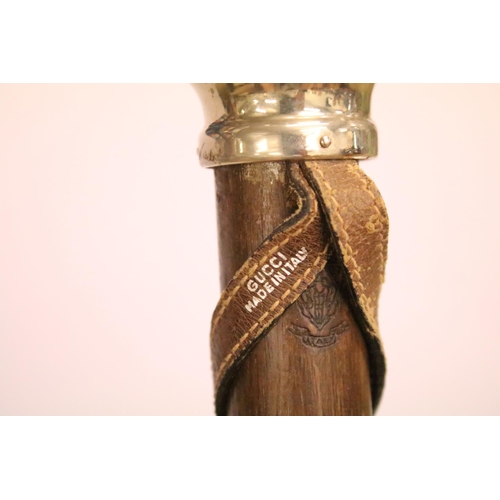 444 - Vintage wooden card display marked Gucci, with twin metal pommel ends, approx 83cm long