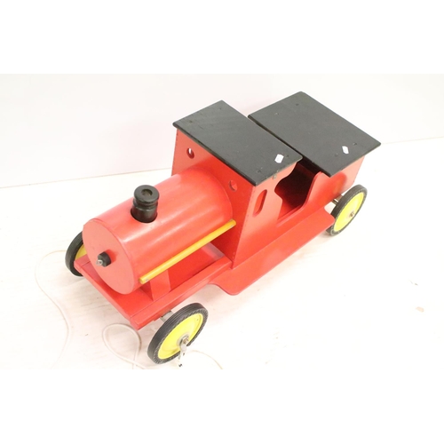 489 - Painted wooden model of a train, raised on four wheels with metal hubs, approx 73cm long