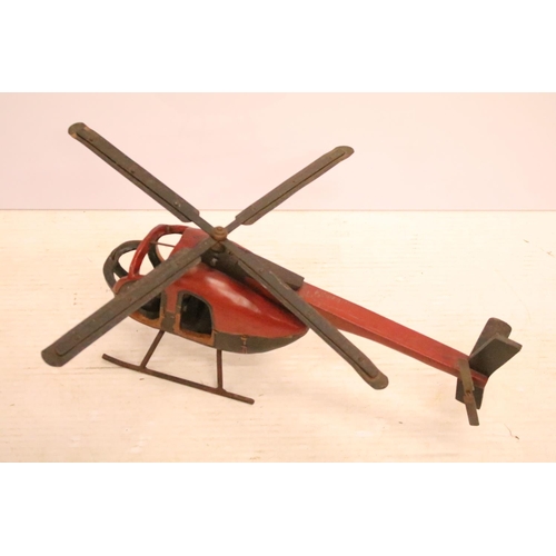 502 - Painted wooden helicopter with metal propellors, complete with pilot, approx 70cm long