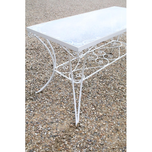518 - White painted metal patio table set comprising a glass topped table with eight chairs and two glass ... 