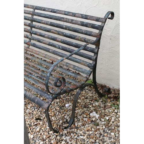 520 - Cast iron slatted garden bench raised on two wrought iron supports of scrolled form, approx 183m W x... 