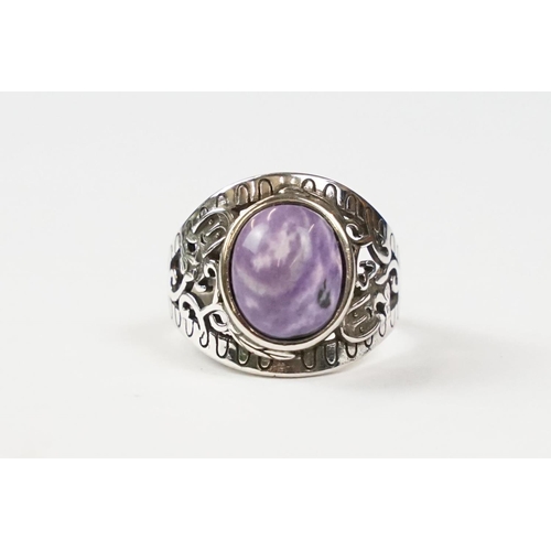 305 - A 925 sterling silver ladies ring with purple cabochon central stone with decorative shoulder work, ... 