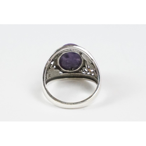 305 - A 925 sterling silver ladies ring with purple cabochon central stone with decorative shoulder work, ... 