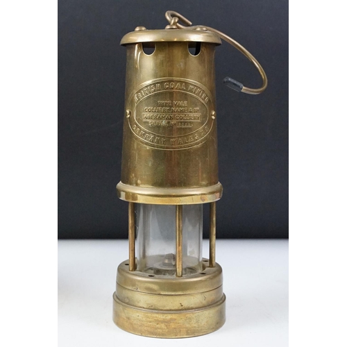 435 - Two 'British Coal Mining' brass miners lamps, together with a pair of barley twist wooden candlestic... 
