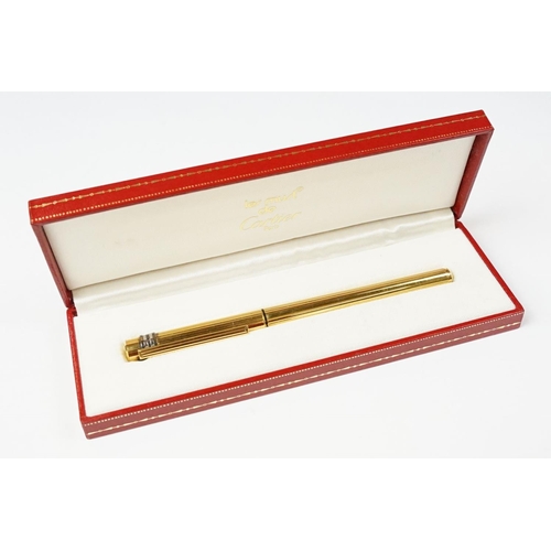 242 - A boxed Cartier leather purse together with a boxed Cartier pen, both with original display boxes.