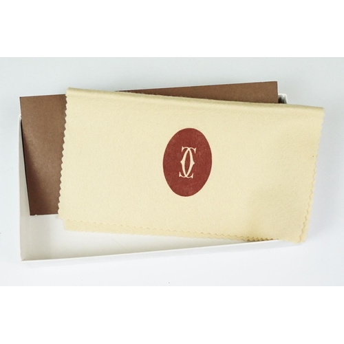 242 - A boxed Cartier leather purse together with a boxed Cartier pen, both with original display boxes.