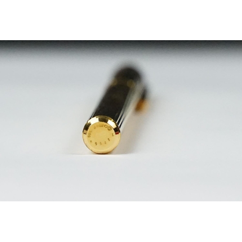 242 - A boxed Cartier leather purse together with a boxed Cartier pen, both with original display boxes.