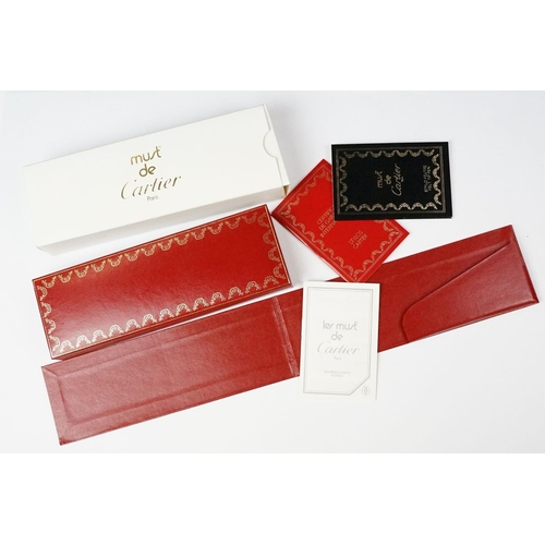 242 - A boxed Cartier leather purse together with a boxed Cartier pen, both with original display boxes.