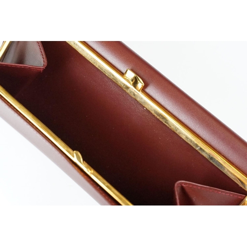 242 - A boxed Cartier leather purse together with a boxed Cartier pen, both with original display boxes.