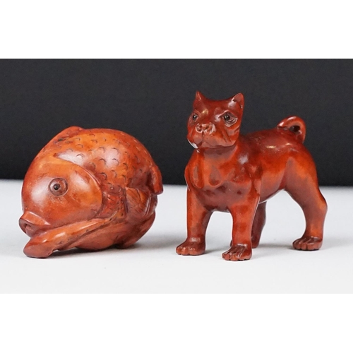 243 - Two carved oriental Netsuke in the form of a dog and a fish.