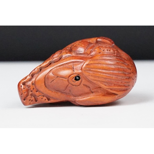243 - Two carved oriental Netsuke in the form of a dog and a fish.