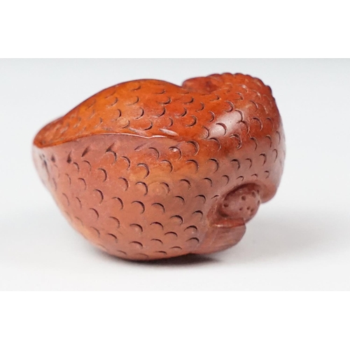 243 - Two carved oriental Netsuke in the form of a dog and a fish.