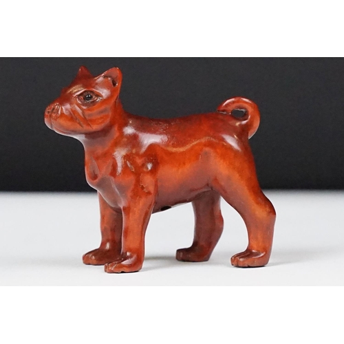 243 - Two carved oriental Netsuke in the form of a dog and a fish.