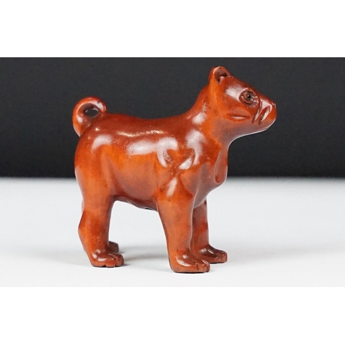 243 - Two carved oriental Netsuke in the form of a dog and a fish.