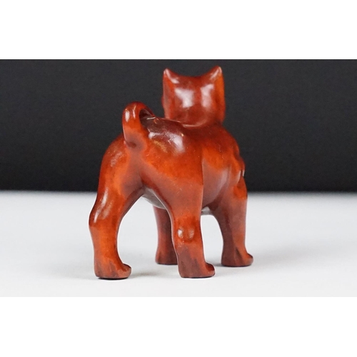 243 - Two carved oriental Netsuke in the form of a dog and a fish.