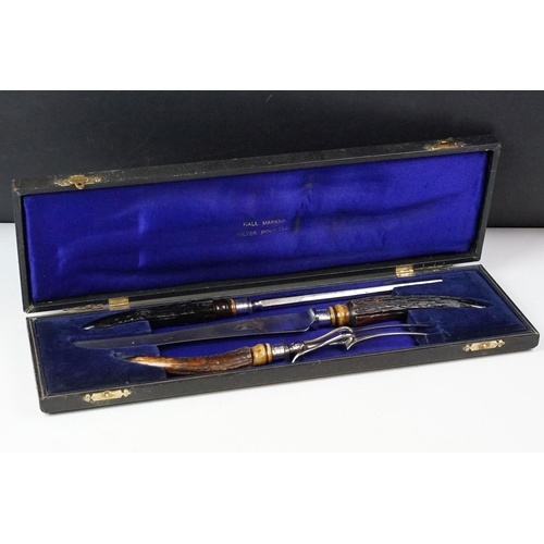 253 - A cased carving set with antler handles and sterling silver mounts.