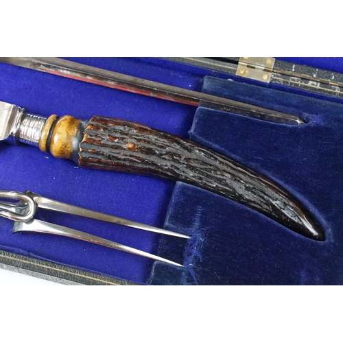 253 - A cased carving set with antler handles and sterling silver mounts.