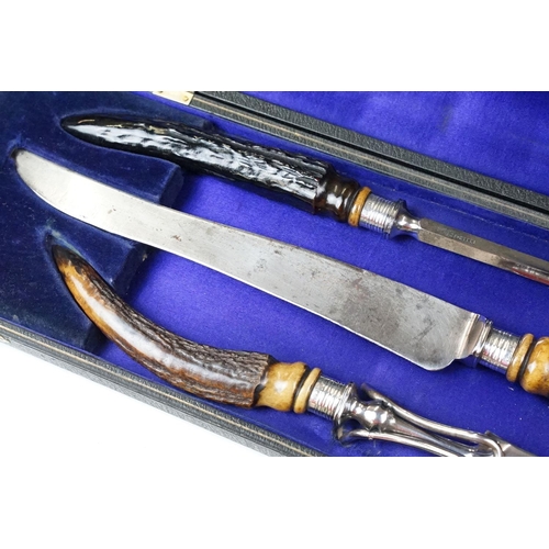 253 - A cased carving set with antler handles and sterling silver mounts.