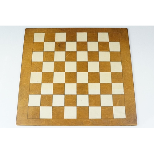 341 - A set of cast metal chessmen in the form of Romans together with a wooden chessboard.